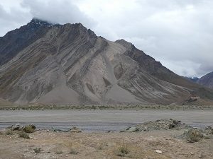 Rangdum Monastery and camp dwarfed by striated low mountains