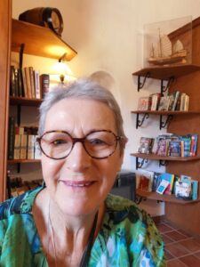 Books on shelves behind Teresa in the 'schoolroom' at Escuela