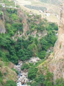 A view of ruined buildings on the lower cliffs below Puente Nuevo Bridge