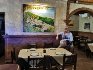 Teresa under the painting of Ojén in El Tunal