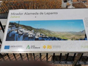A signboard in Mirador de la Alameda de Lepanto Zahara de la Sierra with some mountains in the distance