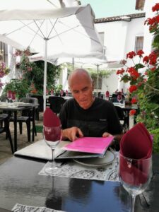 Manfred checking the menu in the courtyard at Torreón Cafe & Copas Grazalema