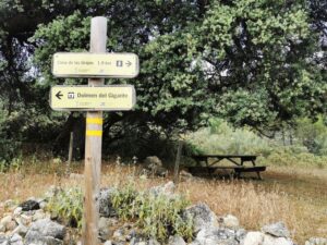 Signs and picnic table in the area of the Dolmen del Gigante