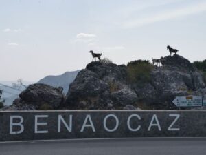 The roadside sculpture of goats on the rocks and the name of the Benaocaz village