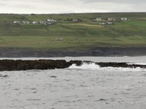 Houses on the terraces above the ocean at the lower end of the Cliffs of Moher