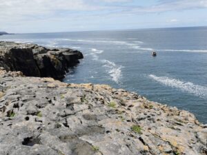 A fishing boat below the cliffs in The Burren