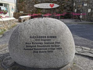 A memorial stone to Alexander Nimmo in Roundstone near a cafe