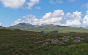 First view of Killary Fjord across the green fields and the mountains behind on a clear lovely day