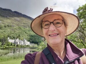 Teresa at Kylemore Abbey below the steep bluffs behind