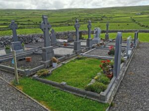 The modern end of the cemetery looking to the hills with ancient rock fences in The Burren