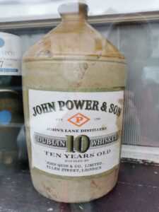 A stone whiskey bottle in the window of a building in Belmullet