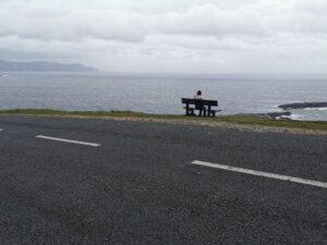 Matilda contemplating on the park bench on the windy hill near Keel, Achill Island