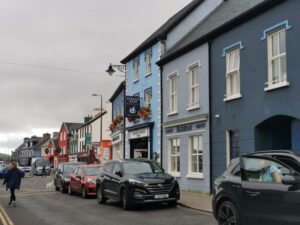 A row of coloured houses and shops on a street near the wharf in Dingle