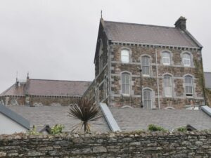 A view over a stone fence towards An Díesart Centre of Irish Spirituality and Culture in Dingle town