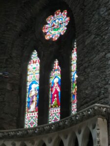 Stained glass windows which highlights the stone walls, in St Mary's Church, Dingle