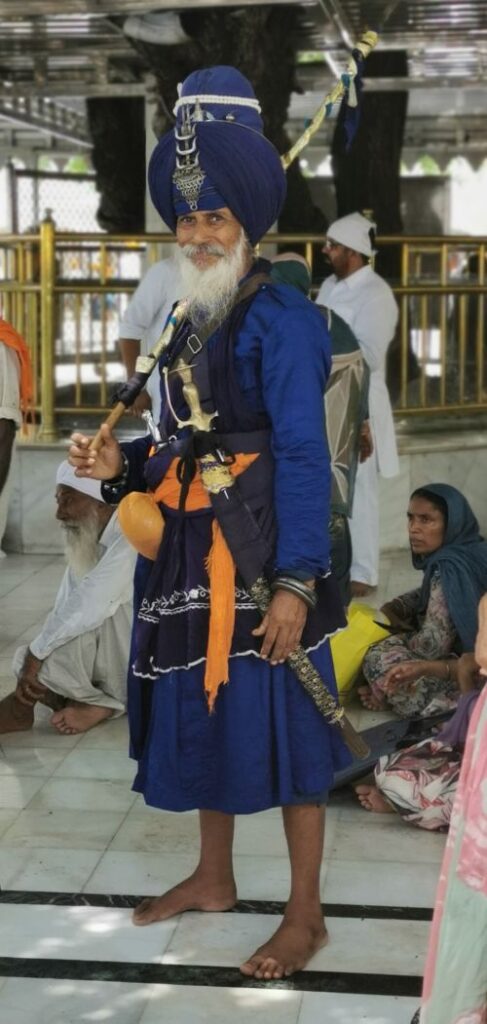 A man at the Golden Temple dresssed in Bana and Dumala turban, the blue clothing worn by the Nihang or Akali,