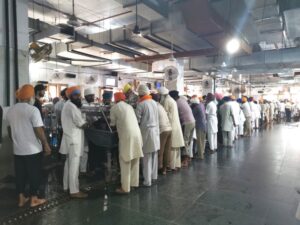 A production line of men cleaning plates in the Langar at Ramgarhia Bunga