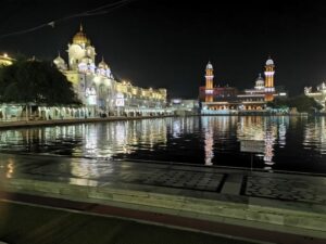 Ber trees, white marble archways at the entrance to the Golden temple and Ramgarhia Bunga lit up in the night sky