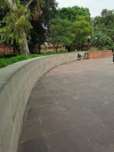 The curved wall behind the Obelisk with someone crouched down listening to their friend at the other end