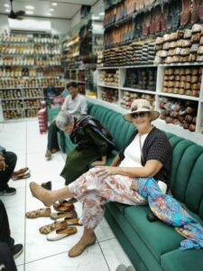 Trying Punjabi Juttis, Mojaris, shoes on in one of the multiple shoe stores