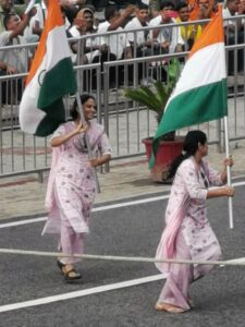 Two Indian women running with flags as part of the entertainment