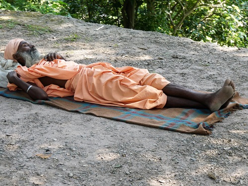 A wandering yogi sleeps by the roadside near Vashistha Gufa Cave, North of Rishikesh