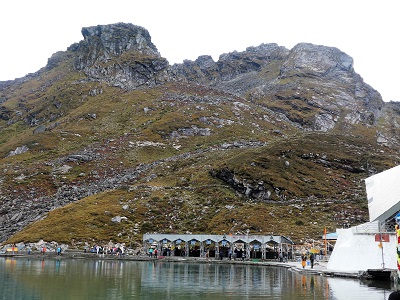 The craggy mountains above the lake at Hemkund. Temple on the right, bathing ghats in the lower centre