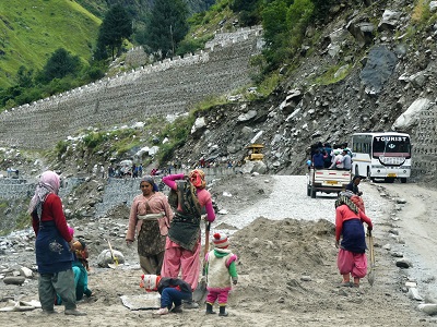 Women with children working on the roads on the way to Badrinath, Himalayas India