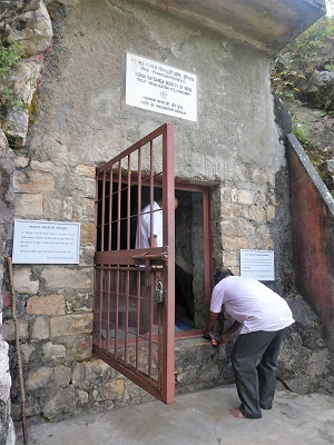 Two men pilgrims enter Babaji's cave to meditate.