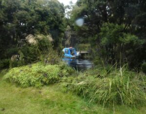 Through the trees and over the river the boat awaits the trampers to return to Golden Bay