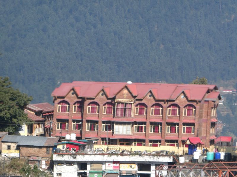 A building from the past set with a background of the Shimla hills