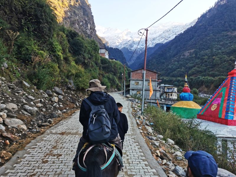 Alice and Rani setting off from Janki Chatti for Yamunotri as the sun hits the rock wall