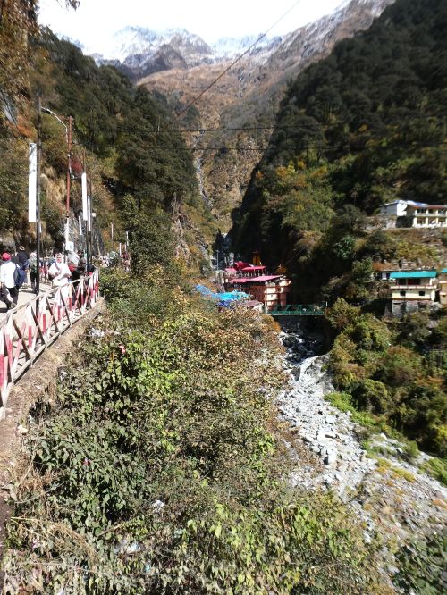 Pilgrims approaching or leaving the Yamunotri temple complex nestled within the gorge below the mountains
