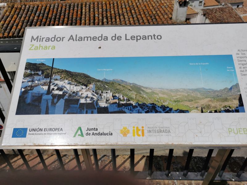 A signboard in Mirador de la Alameda de Lepanto Zahara de la Sierra with some mountains in the distance