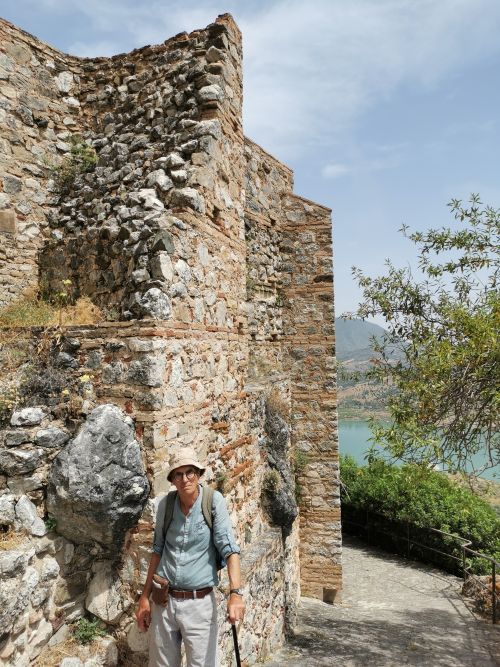 Manfred beside the thick wall on the track up to the castle on the hill Zahara de la Sierra