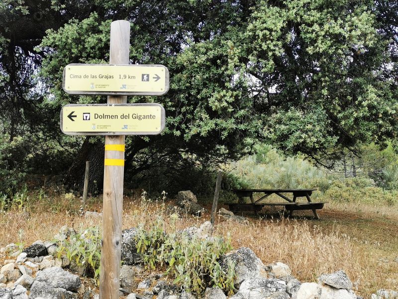 Signs and picnic table in the area of the Dolmen del Gigante