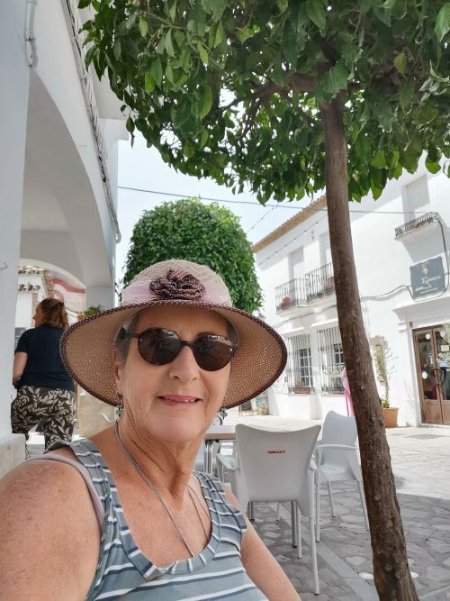 Teresa sitting under an orange tree at a restaurant in Zahara de la Sierra