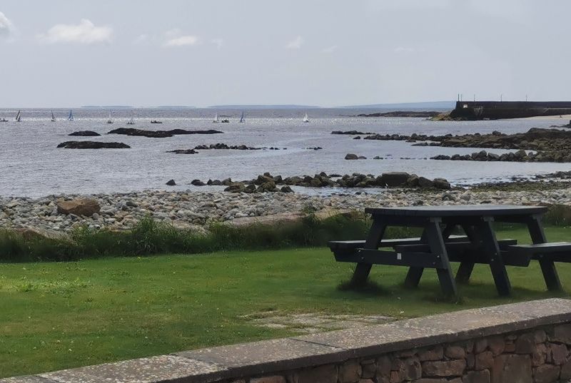 A beautiful view of yachts on Galway Bay, a picnic table and the Aran Islands on the Horizon