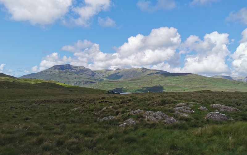 First view of Killary Fjord across the green fields and the mountains behind on a clear lovely day